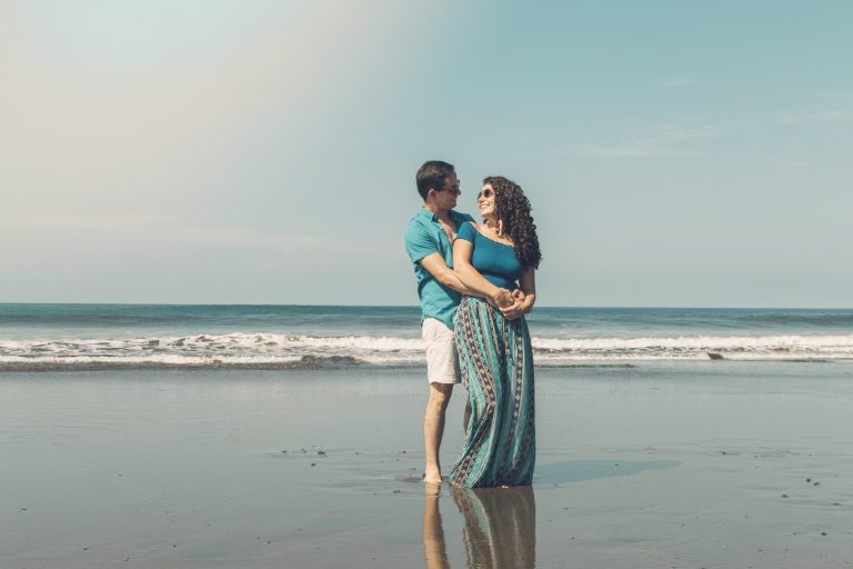 pretty-couple-smiling-looking-each-other-beach